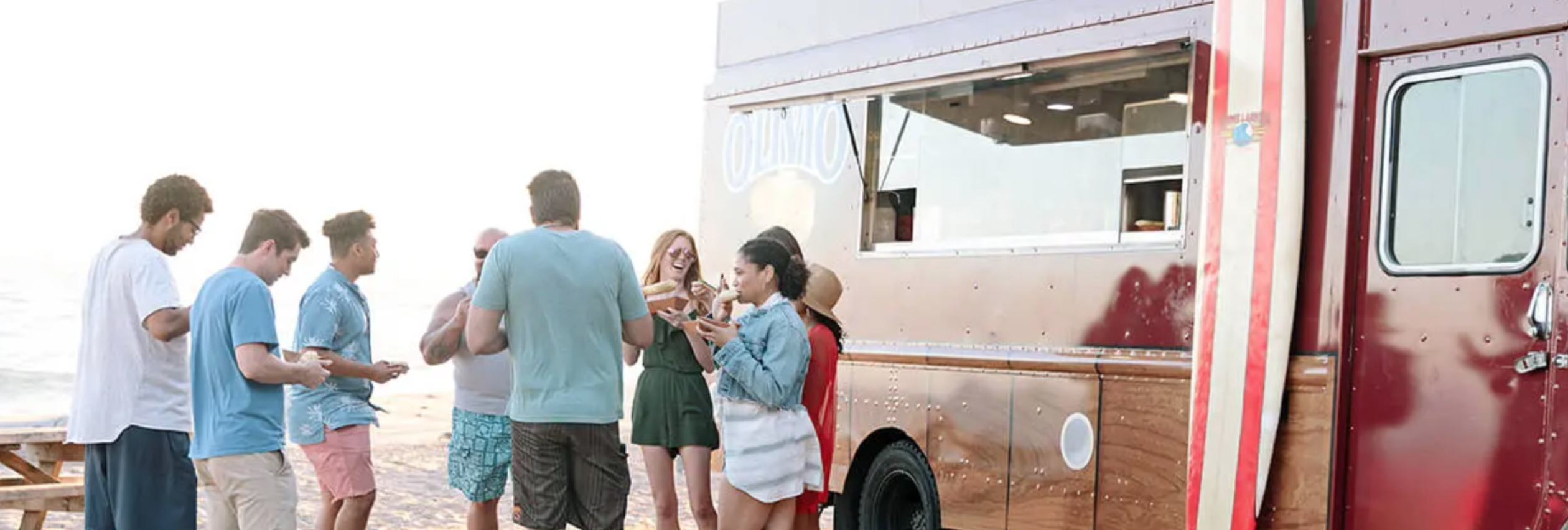 Group gathered around a food truck on the beach